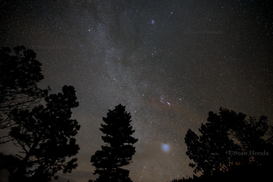 A wide view of the winter Milky Way and Lovejoy (at top of frame). The bright star Sirius glows through thin clouds at the bottom. 