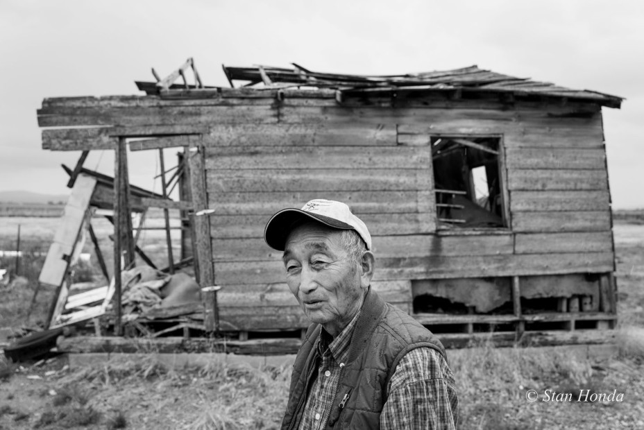 Farmer Tak Ogawa by a dilapidated barrack on his land. He came to the area after the original homesteaders had settled.